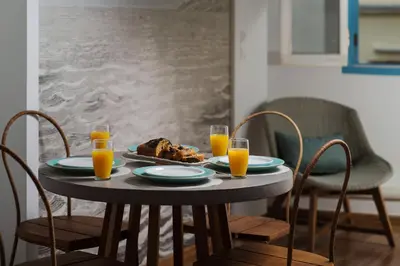 a table with a plate of food and two glasses of orange juice at Aeria Apartments in Chania Town