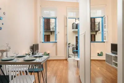 a dining room with a table and chairs and windows at Aeria Apartments in Chania Town