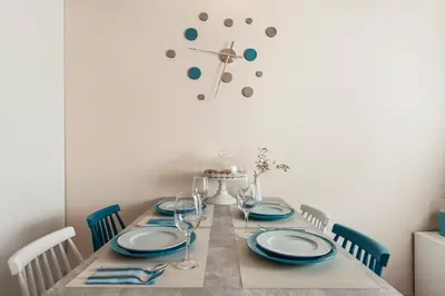 a dining room table with blue plates and a clock on the wall at Aeria Apartments in Chania Town