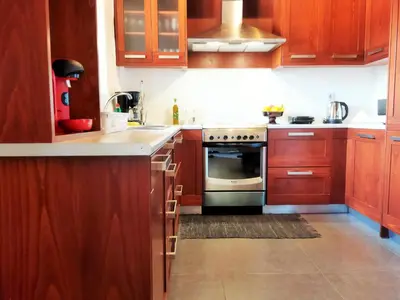 a kitchen with wooden cabinets and a stainless steel oven at Little House on the Prairie - Chania in Katokhórion