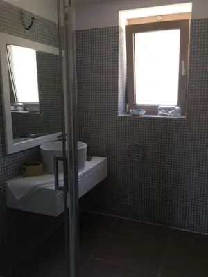 a bathroom with a sink and a toilet and a mirror at Anny's Homes in Kountoura Selino