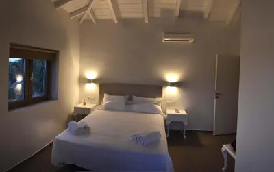 a bedroom with a large white bed with two tables at Anny's Homes in Kountoura Selino