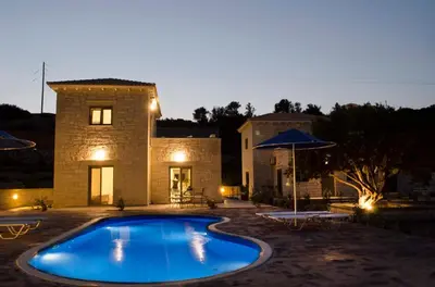 a swimming pool in front of a stone house at Anny's Homes in Kountoura Selino