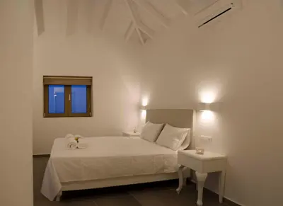 a white bedroom with a bed and a window at Anny's Homes in Kountoura Selino