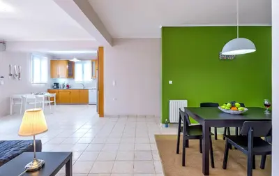 a living room with a table and a green wall at Horizon Villa Kampani in Kambánion