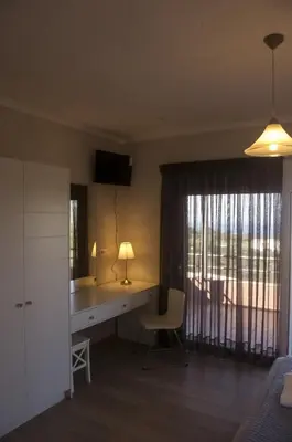 a bedroom with a desk and a bed and a window at Horizon Villa Kampani in Kambánion