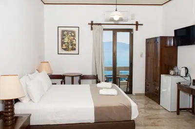 a hotel room with a bed and a balcony at Argo Rooms-Papadakis in Kissamos