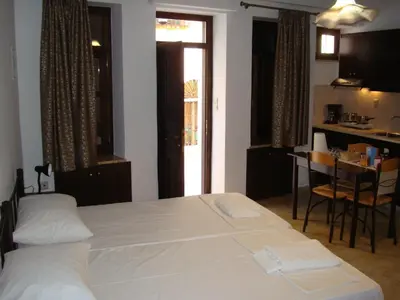 a bedroom with a bed and a table and a kitchen at Old Town Apartments in Chania Town
