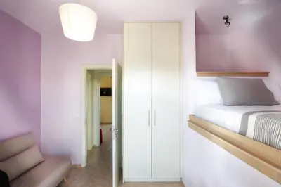 a bedroom with purple walls and a bed and a chair at Dream Villa in Kambánion