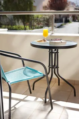 a table and a chair on a balcony with a drink at Dream Villa in Kambánion