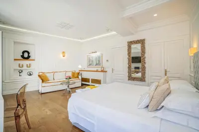 a white bedroom with a large bed and a couch at Casa Kallergi in Chania Town