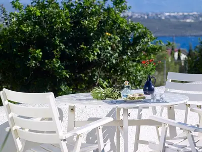 a white table and chairs with a plate of food on it at Villa Mare in Tersanas