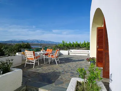 a patio with chairs and a table with a view at Villa Mare in Tersanas