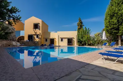 a villa with a swimming pool in front of a house at Iliopetra in Douliana