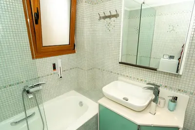 a bathroom with a sink and a tub and a mirror at Contemporary 2 bedroom apt 5 min walk from Kissamos center in Kissamos