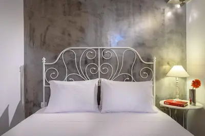 a bedroom with a white bed with a metal headboard at Lithinon House in Chania Town