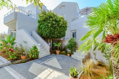 a villa with a courtyard and plants at Gelina Apartments in Plataniás