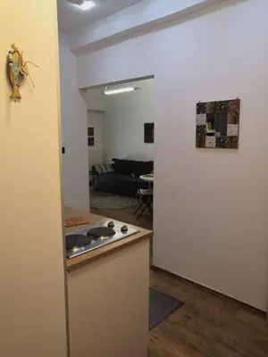 a kitchen with a stove and a living room at City Square Apartment in Chania Town