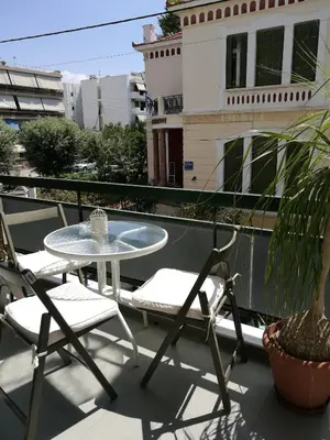 a patio with a table and chairs on a balcony at City Square Apartment in Chania Town