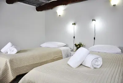 a room with two beds with white sheets and towels at Villa Lakki Heated round pool Jacuzzi in Lákkoi