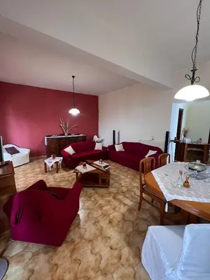 a living room with red walls and a table and chairs at Falassarna House in Plátanos