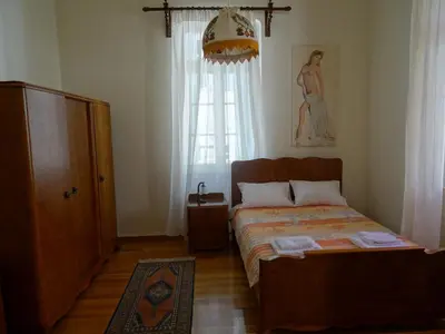 a bedroom with a bed and a dresser and a window at Neoclassical House in Chania Town