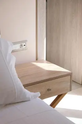 a bed with a wooden table in a room at Glaros Casa Verde - Cozy flat with Garden near Beach in Kato Daratso
