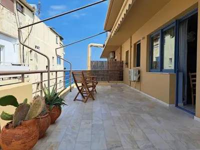 a balcony with chairs and plants on a building at Nais Apartments & Studios in Chania Town