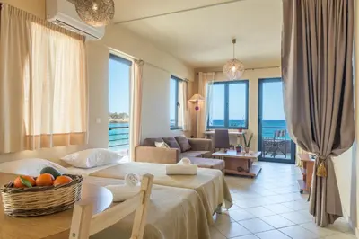 a hotel room with two beds and a living room at Nais Apartments & Studios in Chania Town