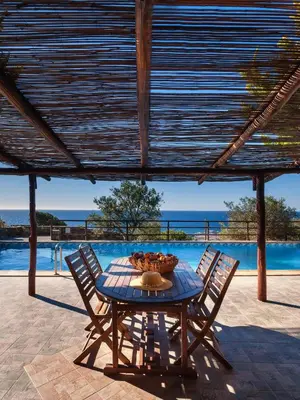 a table with chairs and a bowl of fruit on it at Villa Kimothoe with Private Pool, only 20 min to Elafonissi Beach in AmigdhalokeFálion