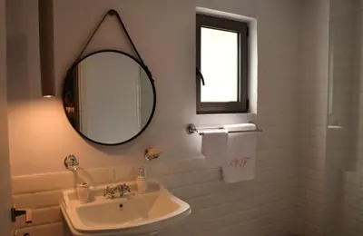 a white bathroom with a sink and a mirror at Evaris Apartments in Chania Town
