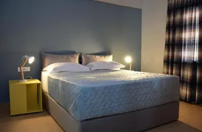 a bedroom with a large bed with white sheets and pillows at Evaris Apartments in Chania Town