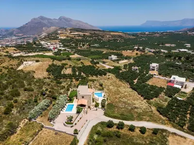 an aerial view of a house on a hill with the ocean at Adam Villas in Falasarna