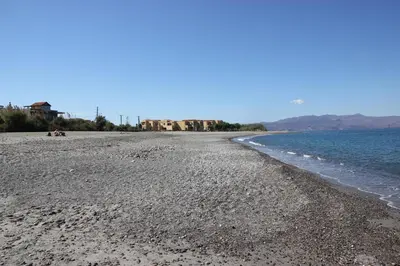 a beach with a rocky shoreline next to the water at Tasos Cottages in Gerani Chanion