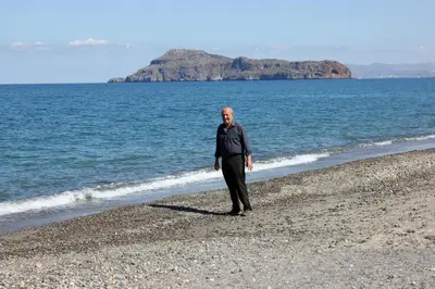 a man standing on a beach near the water at Tasos Cottages in Gerani Chanion