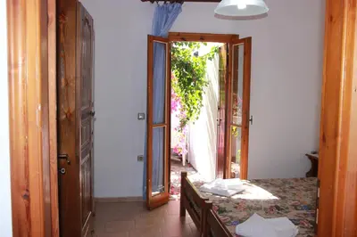 a room with a table and an open door at Tasos Cottages in Gerani Chanion