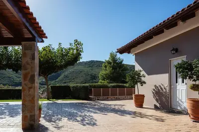 a house with a driveway with a mountain in the background at Epimenidis House in Sinoikismós Kondoudhianá