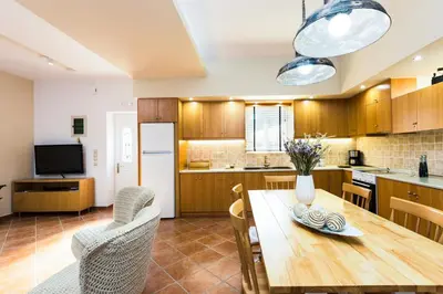 a kitchen and dining room with a wooden table and chairs at Epimenidis House in Sinoikismós Kondoudhianá