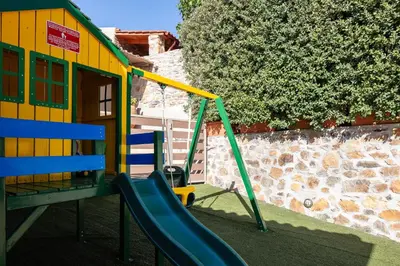 a playground with a slide in front of a building at Epimenidis House in Sinoikismós Kondoudhianá