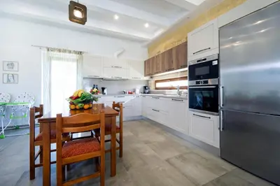 a kitchen with a table and a stainless steel refrigerator at Iridanos Villa in Kissamos