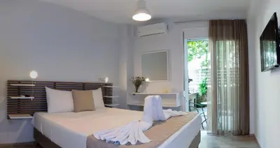 a white bedroom with a bed and a balcony at Urban 35 in Chania Town