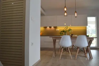 a kitchen with a wooden table and two white chairs at Urban 35 in Chania Town