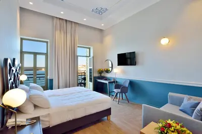 a bedroom with a bed and a desk and a couch at Elia Palatino Hotel in Chania Town