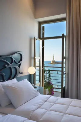 a bedroom with a bed with a view of the ocean at Elia Palatino Hotel in Chania Town