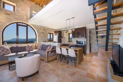a kitchen and living room with a couch and a table at Villa Kourouni in Stalos
