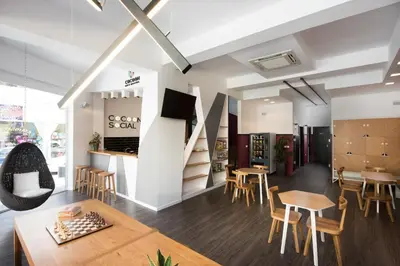 a room with tables and chairs and a staircase at Cocoon City Hostel in Chania Town