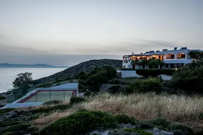 a house on top of a hill with a tennis court at Alianthos Villa in Tersanas
