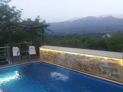 a swimming pool with a view of the mountains at Stone Mansion in Káïna