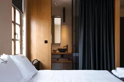 a bedroom with a bed and a bathroom with a sink at Monastery Estate Venetian Harbor in Chania Town