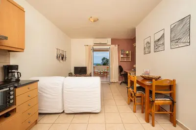 a kitchen with a table with white pillows at Mini Art Apartments in Gerani Chanion
